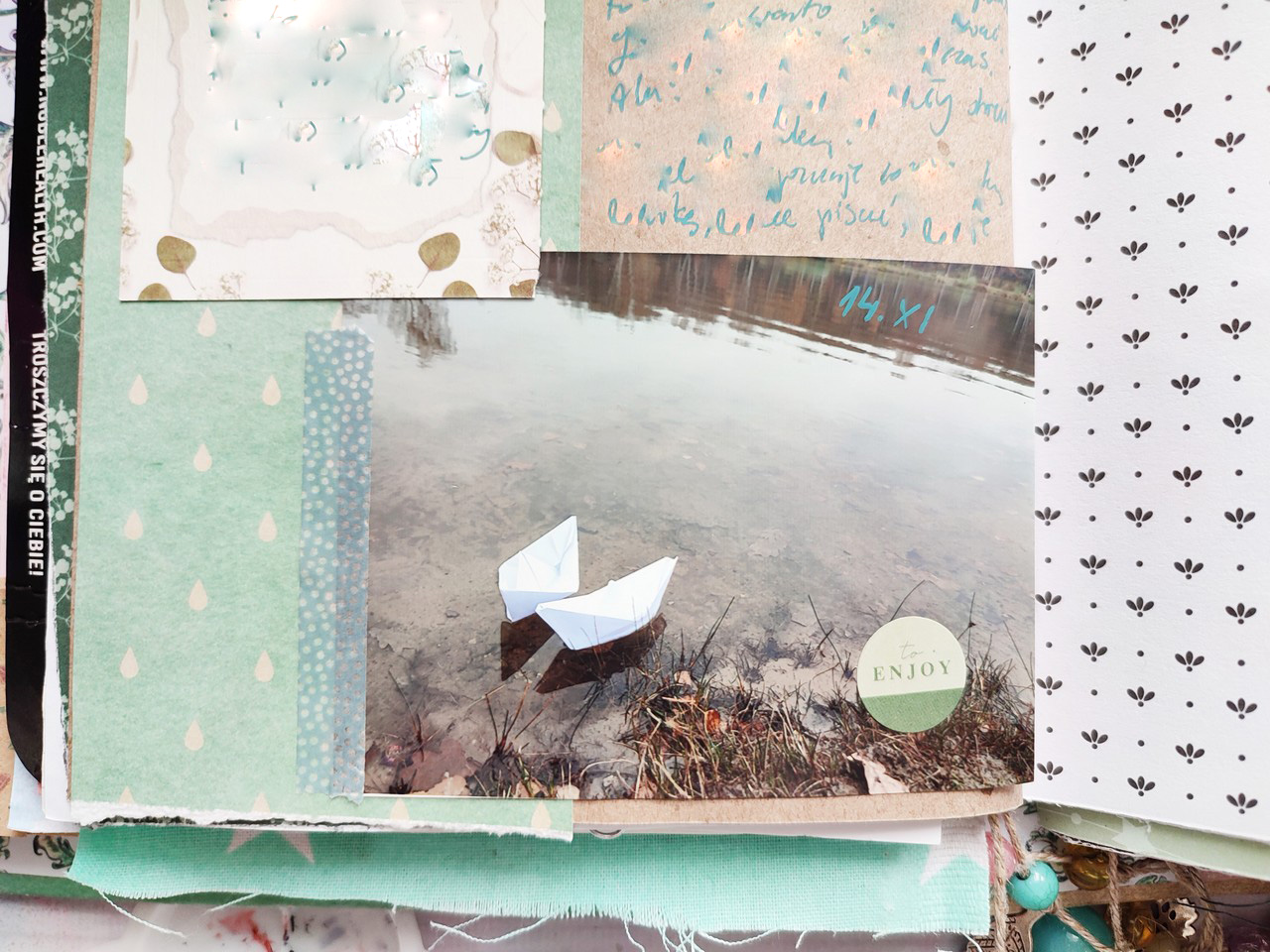 Close-up of a photo with paper boats and notes in a junk journal.